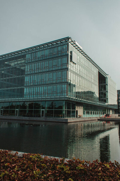 Selective focus of building with glass facade near canal on urban street in Copenhagen, Denmark 