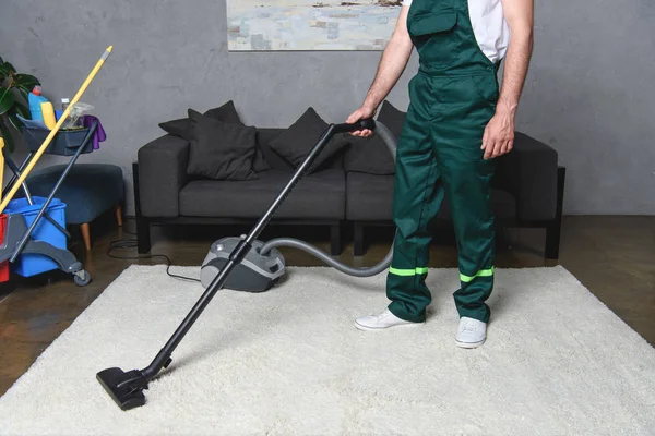 Tiro recortado del hombre utilizando aspiradora y limpieza de alfombras blancas - foto de stock