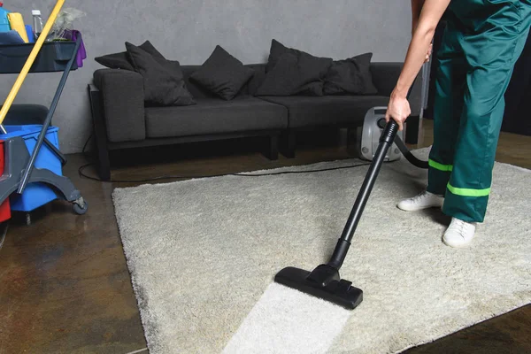 Plan recadré de la personne en utilisant l'aspirateur tout en nettoyant tapis blanc — Photo de stock