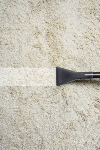 Vista ravvicinata della pulizia tappeto bianco con aspirapolvere professionale — Foto stock