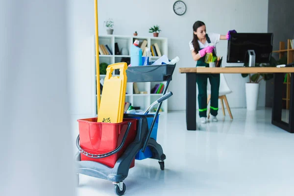 Giovane donna inserviente ufficio di pulizia con varie attrezzature per la pulizia — Foto stock