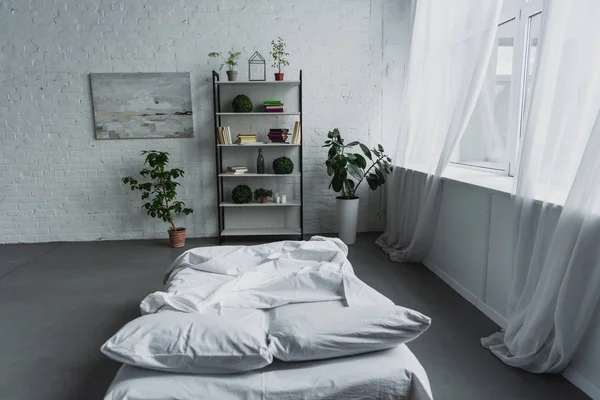 Design de interiores moderno do quarto com rack, plantas, cama, parede de tijolo e espaço de cópia — Fotografia de Stock