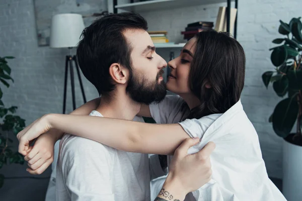 Belo romântico jovem casal olhando um para o outro e abraçando em casa — Fotografia de Stock