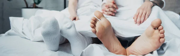 Vista cortada do casal deitado na cama em casa — Fotografia de Stock