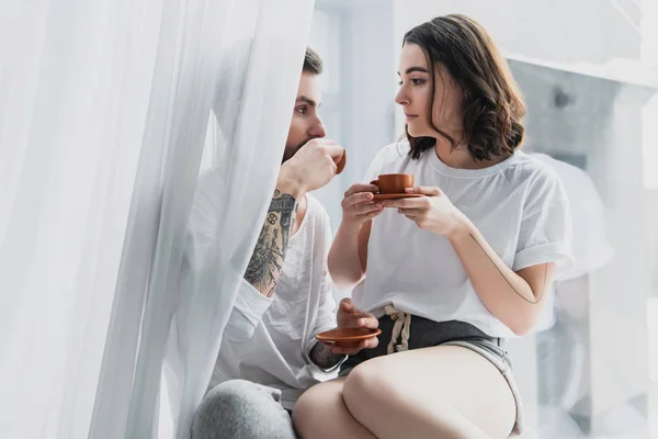 Beau jeune couple boire du café à la maison le matin — Photo de stock