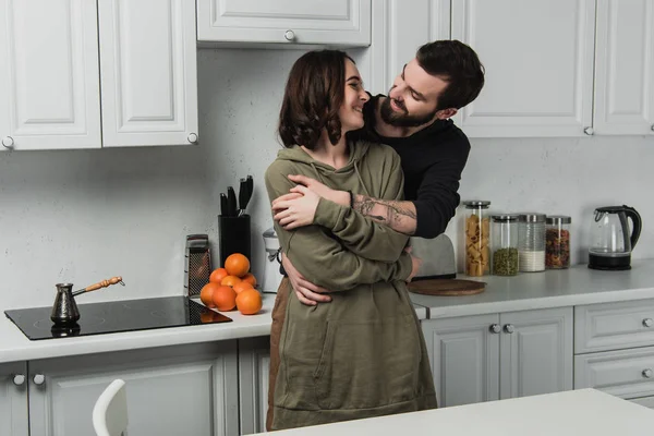 Schönes junges Paar umarmt und lächelt in Kithchen beim Frühstück — Stockfoto