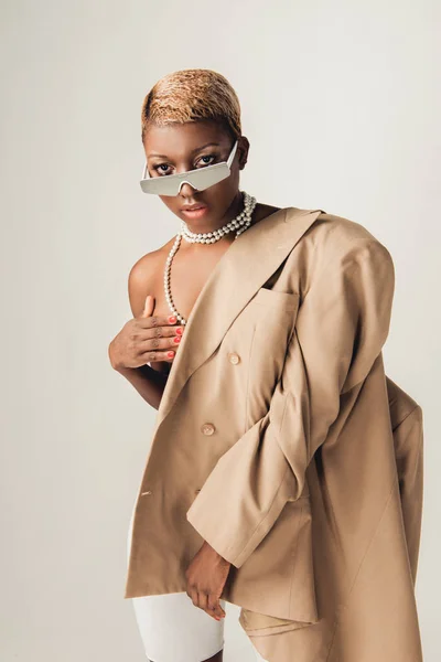 Nu afro-américaine fille posant en veste beige isolé sur gris — Photo de stock