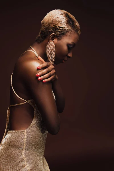 Hermosa mujer afroamericana elegante con pelo corto aislado en marrón - foto de stock