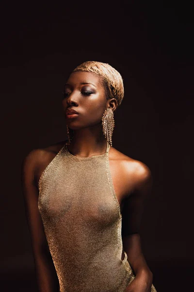 Красивая африканская американка с короткими волосами в гламурном платье, изолированном от коричневого — стоковое фото