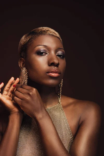 Красива гламурна афроамериканська жінка з сережками ізольована на коричневому — стокове фото