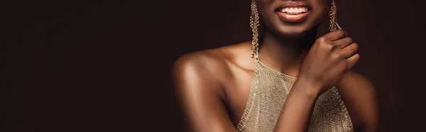 Cropped view of smiling african american woman with earrings isolated on brown — Stock Photo