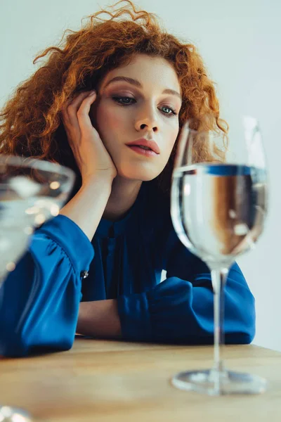 Selektiver Fokus attraktiver, stylischer rothaariger Frau, die Glas mit Wasser betrachtet — Stockfoto