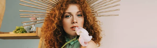 Panoramic shot of woman with accessory on head posing with flower — Stock Photo