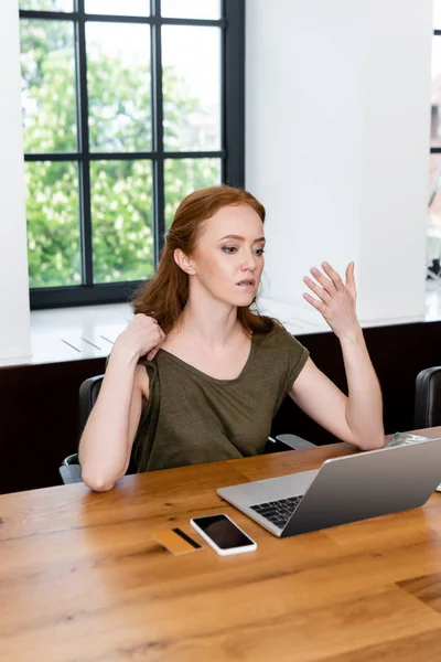 Freelancer que sufre de calor cerca de aparatos y tarjeta de crédito en la mesa en casa — Stock Photo