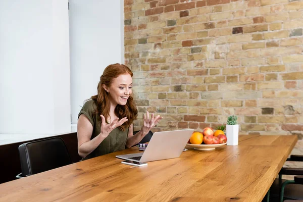 Sonriente gesto teletrabajador durante la entrevista de trabajo en el ordenador portátil en casa - foto de stock