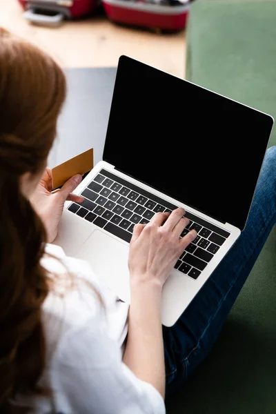 Selective focus of woman using laptop and credit card at home — Stock Photo