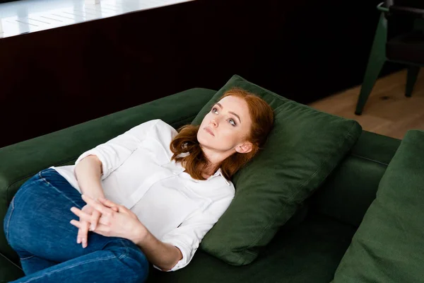 Focus selettivo della donna depressa con le mani serrate sdraiata sul divano — Foto stock