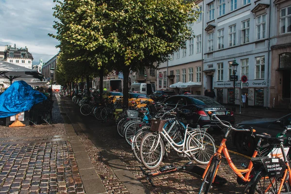 COPENHAGEN, DENMARK - APRIL 30, 2020: Bicycles near road on urban street with sunlight — Stock Photo