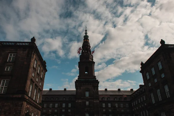 Низкий угол обзора датских флагов фасада Кристиансборгского дворца в Копенгагене, Дания — стоковое фото