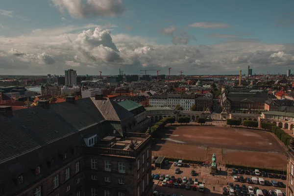 Vista ad alto angolo del campo e auto vicino a Christiansborg Palace con cielo nuvoloso sullo sfondo a Copenaghen, Danimarca — Foto stock