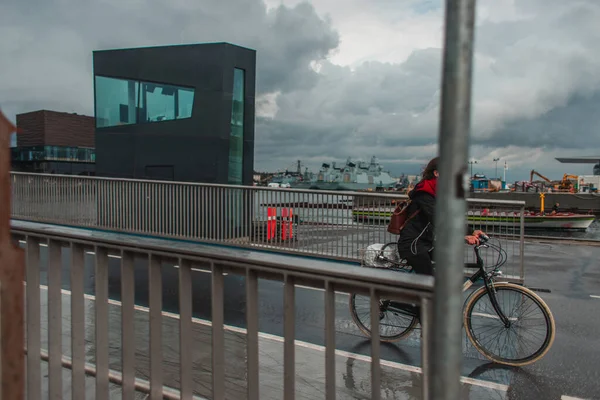 Focus selettivo della donna in bicicletta sulla strada urbana durante la pioggia a Copenaghen, Danimarca — Foto stock