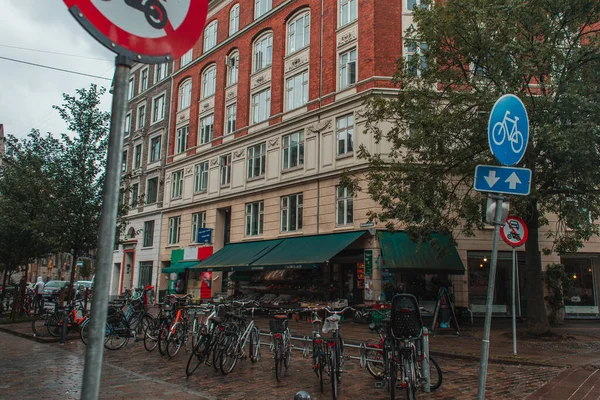 Selective focus of bicycles and road signs on urban street in Copenhagen, Denmark — стоковое фото