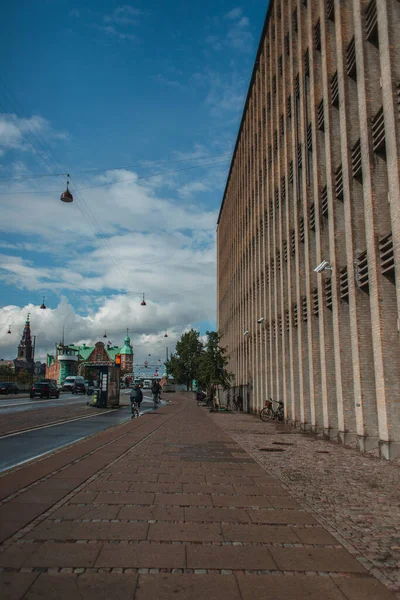 Urban street with walkway near building and road with cloudy sky at background in Copenhagen, Denmark — Stock Photo