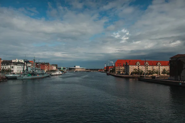 Edificios cerca del canal y barcos en el puerto con cielo nublado en el fondo en Copenhague, Dinamarca — Stock Photo