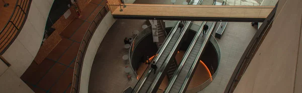 COPENHAGEN, DINAMARCA - 30 DE ABRIL DE 2020: Cultivo panorámico de personas en escaleras mecánicas en Black Diamond Royal Library, Copenhague, Dinamarca - foto de stock