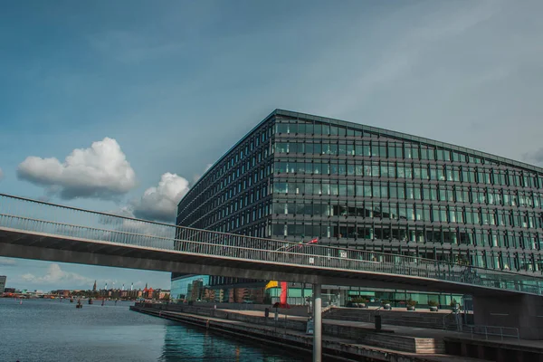 Puente sobre el río con la construcción y el cielo azul con nubes en el fondo en Copenhague, Dinamarca - foto de stock