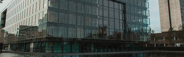 Panoramic shot of building with glass facade near canal on urban street in Copenhagen, Denmark — Stock Photo