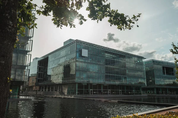 Selective focus of glass facade of building near canal with cloudy sky at background, Copenhagen, Denmark — Stock Photo
