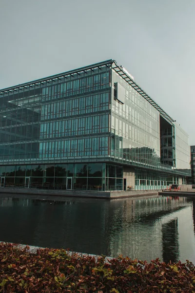 Concentration sélective du bâtiment avec façade vitrée près du canal sur la rue urbaine de Copenhague, Danemark — Photo de stock