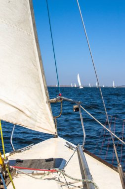 Çift, yelkenli teknenin güvertesinden gün batımının keyfini çıkarıyor.