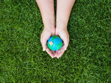 Dünya günü. dünya el ve yeşil çim alan arka plan. çevre dünya kavramı kaydetmek.