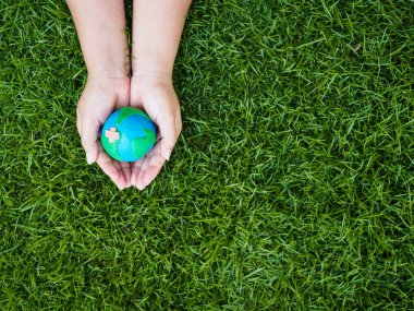 Dünya günü. dünya el ve yeşil çim alan arka plan. çevre dünya kavramı kaydetmek.