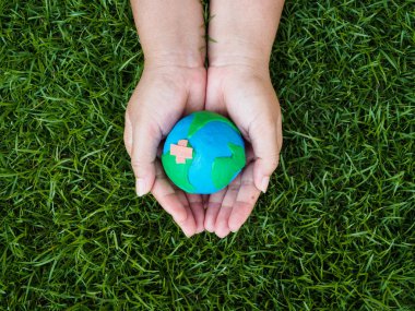 Dünya günü. dünya el ve yeşil çim alan arka plan. çevre dünya kavramı kaydetmek.