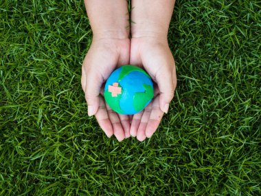 Dünya günü. dünya el ve yeşil çim alan arka plan. çevre dünya kavramı kaydetmek.