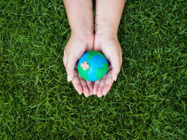 Dünya günü. dünya el ve yeşil çim alan arka plan. çevre dünya kavramı kaydetmek.