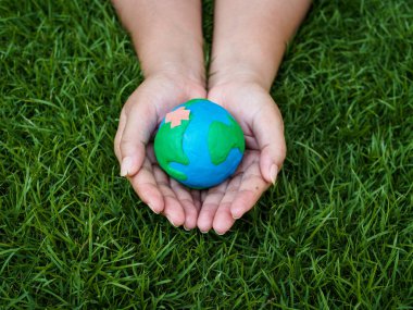 Dünya günü. dünya el ve yeşil çim alan arka plan. çevre dünya kavramı kaydetmek.