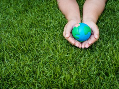 Dünya günü. dünya el ve yeşil çim alan arka plan. çevre dünya kavramı kaydetmek.