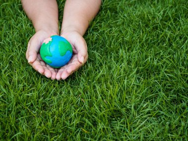 Dünya günü. dünya el ve yeşil çim alan arka plan. çevre dünya kavramı kaydetmek.
