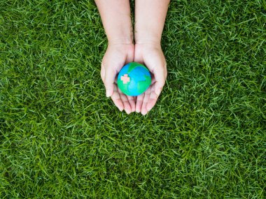 Dünya günü. dünya el ve yeşil çim alan arka plan. çevre dünya kavramı kaydetmek.