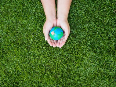 Dünya günü. dünya el ve yeşil çim alan arka plan. çevre dünya kavramı kaydetmek.