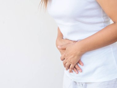 Beyaz arka plan üzerinde acı karın ağrısı olan genç güzel kadın. Kronik gastrit. Karında şişkinlik kavramı.