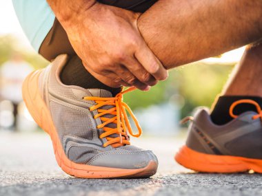 Atlet adamın ayak bileği yaralanması, eğitim çalışan sırasında burkulan bacak var. spor kavramı.