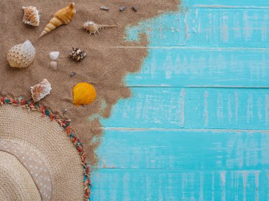 Şapka beach, kabuk, kum parlak dahil plaj aksesuarları pastel ahşap arka plan için yaz tatil ve tatil kavramı mavi.