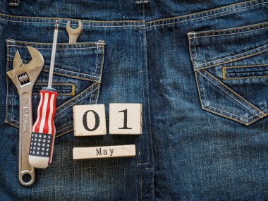 ahşap blok Takvim 1 Mayıs ve Sanayi araçlar jean doku arka plan üzerinde. İşçi Bayramı kavramı.