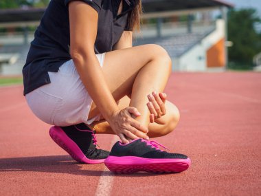Sporcu kadın ayak bileği yaralanması, eğitim çalışan sırasında burkulan ayak vardır. spor kavramı.