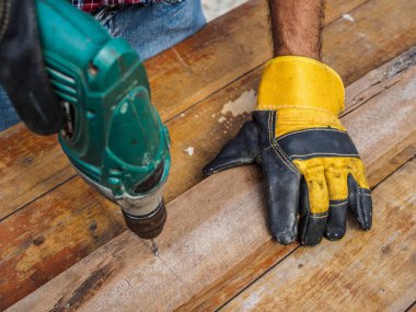 Marangoz bir elektrikli matkapla delik matkap. Meslek, doğrama, doğrama ve insanlar kavramı.